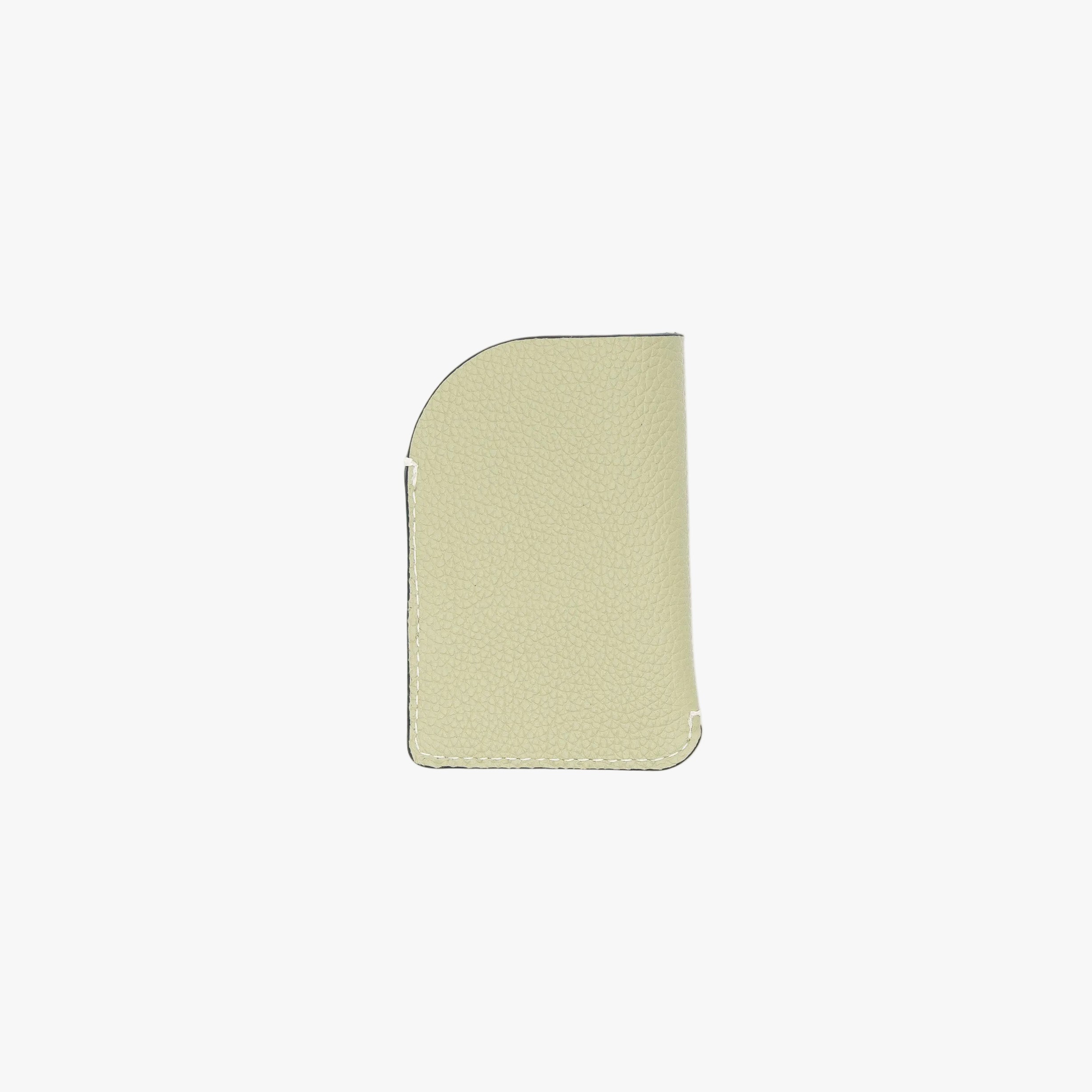 Back panel of STOW London's Mini Cardholder in Pale Green pebbled leather on a light grey background featuring a small gold embossed logo on the front bottom