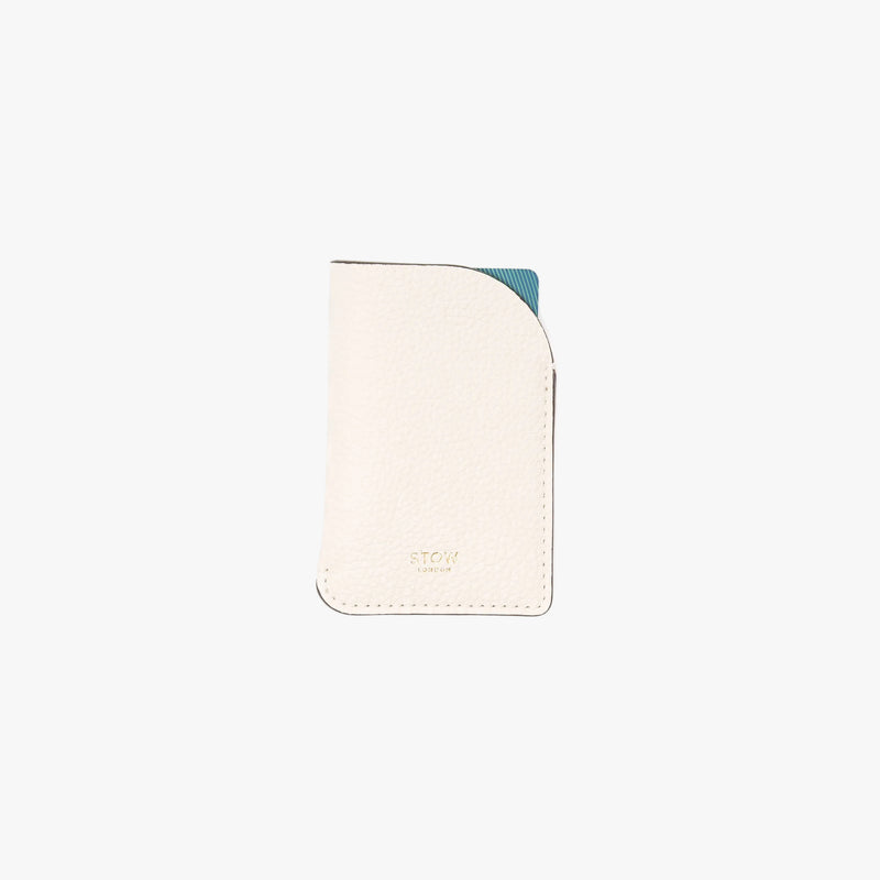 STOW London's Mini Cardholder in Spring Moon pebbled leather with a blue card inside on a light grey background featuring a small gold embossed logo on the front bottom