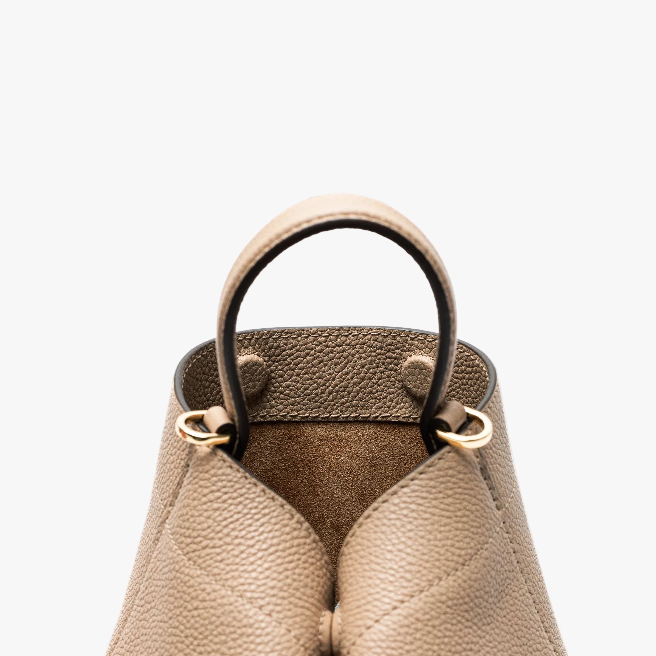 Close up of the top of STOW London's Mini Curve in Camel pebbled leather featuring gold-coated stainless steel hardware and hidden magnetic closures on a light grey background 