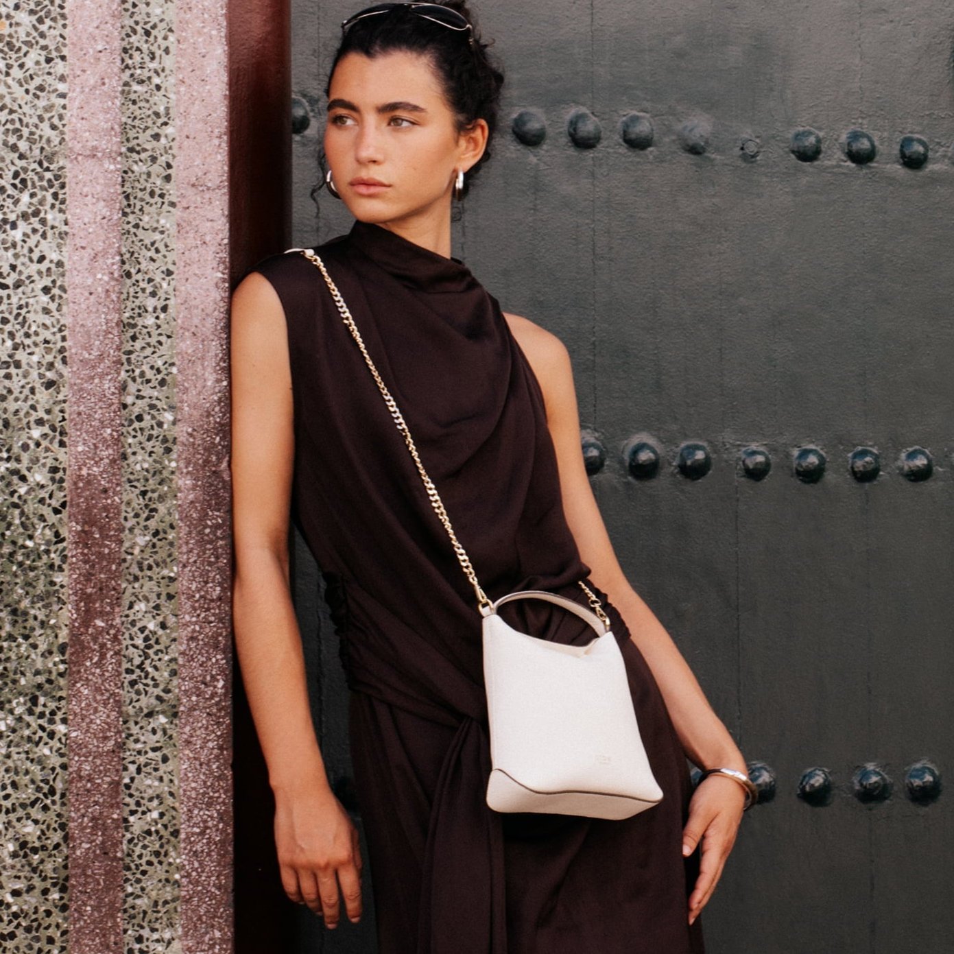 STOW London Mini Curve Bag in Spring Moon leather held by model in Tangiers photo shoot.