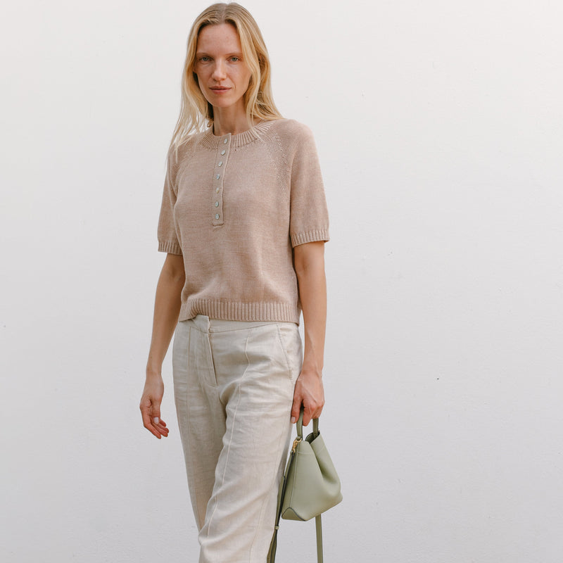Model holding STOW London's Mini Curve in Pale Green Pebbled leather