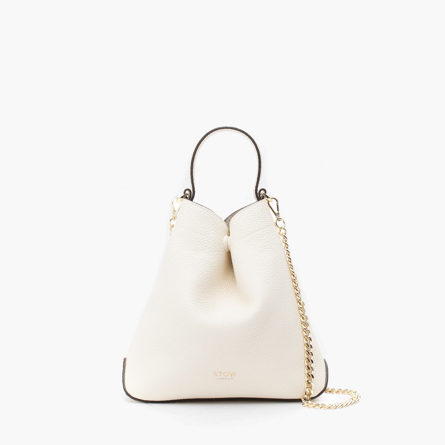 STOW London's Mini Curve in Spring Moon pebbled leather and detachable gold chain crossbody strap on a light grey background 
