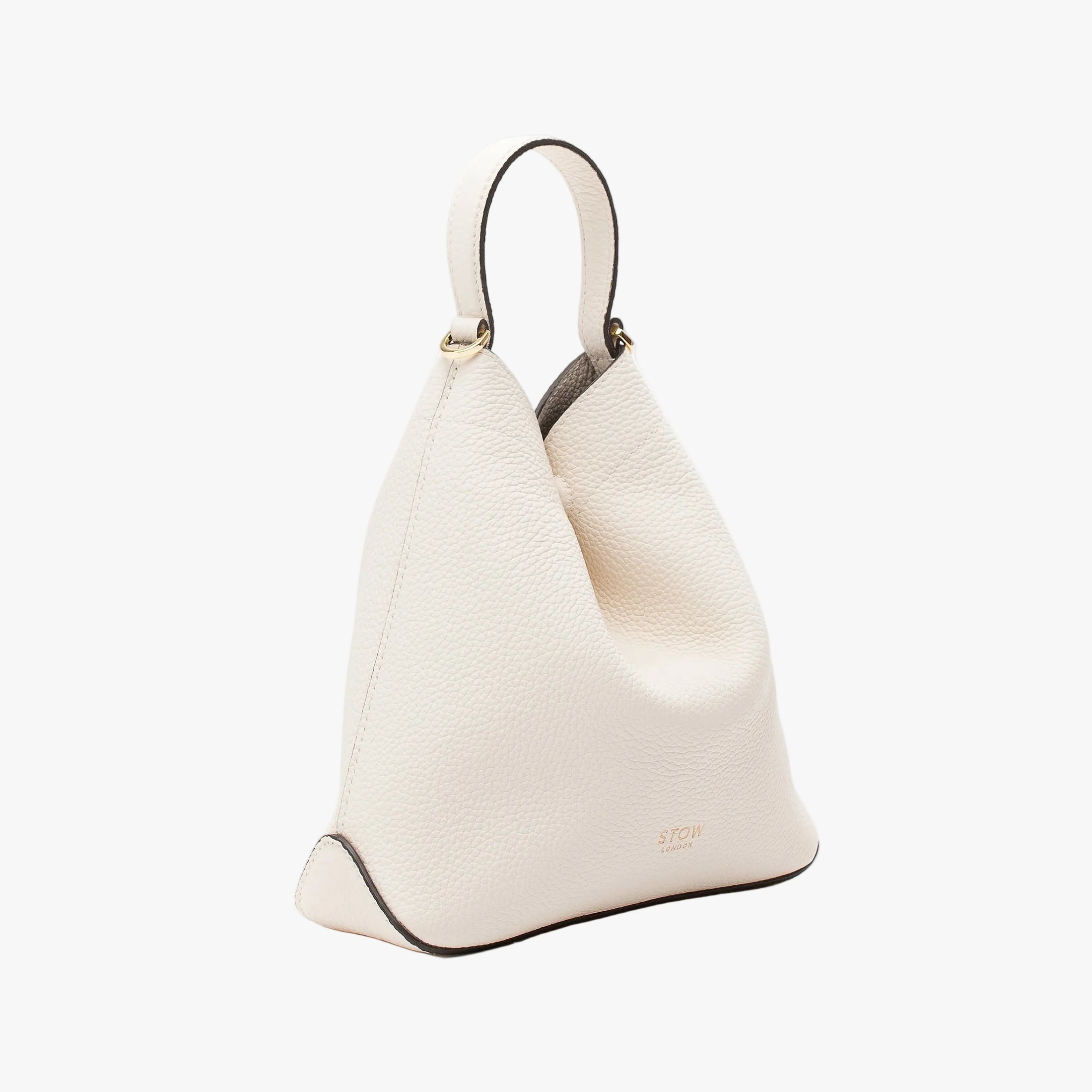 Off-axis view of STOW London's Mini Curve in Spring Moon pebbled leather on a light grey background 
