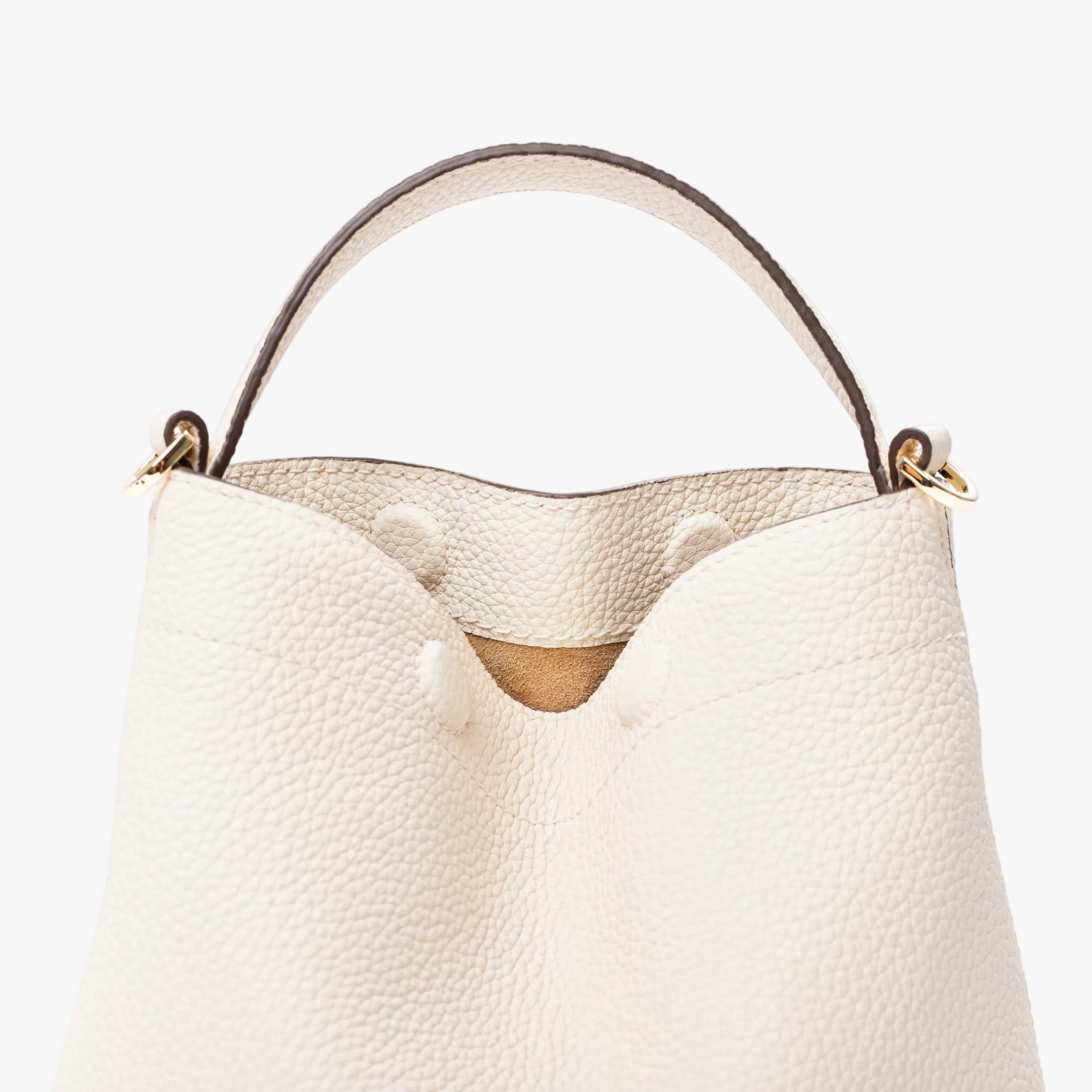 Close up of STOW London's Mini Curve in Spring Moon pebbled leather featuring the hidden magnetic closures, gold hardware and suede interior lining on a light grey background 