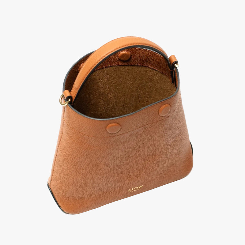 Top view of STOW London's Mini Curve in Earth tan pebbled leather on a light grey background with magnets open showing the suede interior