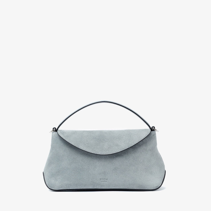 STOW London's Mini East West in Misty Blue suede leather featuring silver stainless steel hardware on a light grey background
