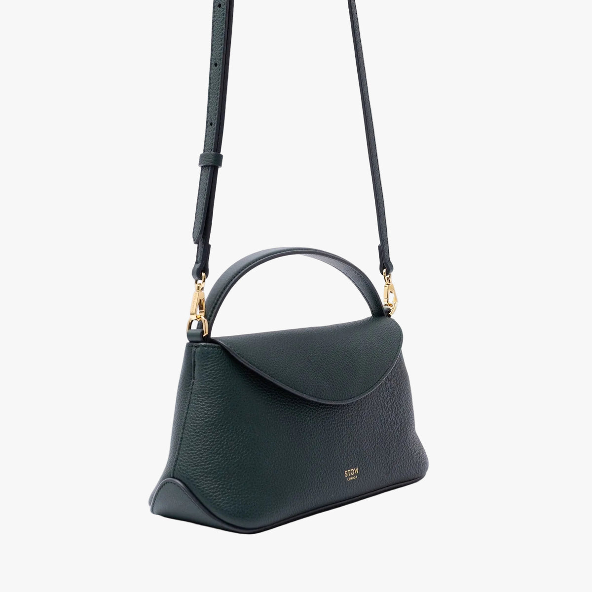 Off-axis view of STOW London's Mini East West in New Forest pebbled leather on a light grey background featuring gold-coated stainless steel hardware and the detachable crossbody strap