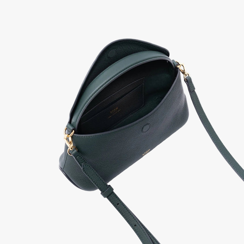 Top view of STOW London's Mini East West in New Forest pebbled leather on a light grey background with the flap open showing the suede interior lining and leather slip pocket