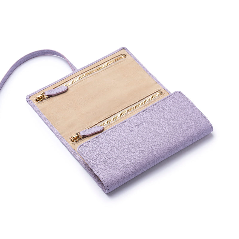 STOW London Mini Jewellery Roll in Wild Lavender leather, half open showing zipped pockets and suede lining.