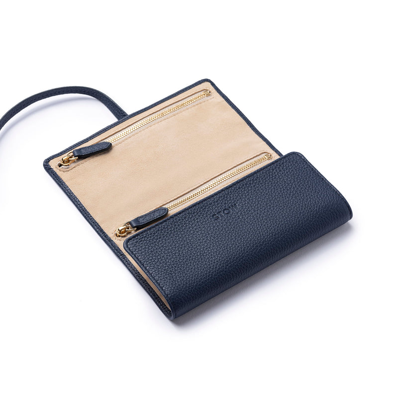 STOW London Mini Jewellery Roll in Navy leather, half open showing zipped pockets and suede lining.
