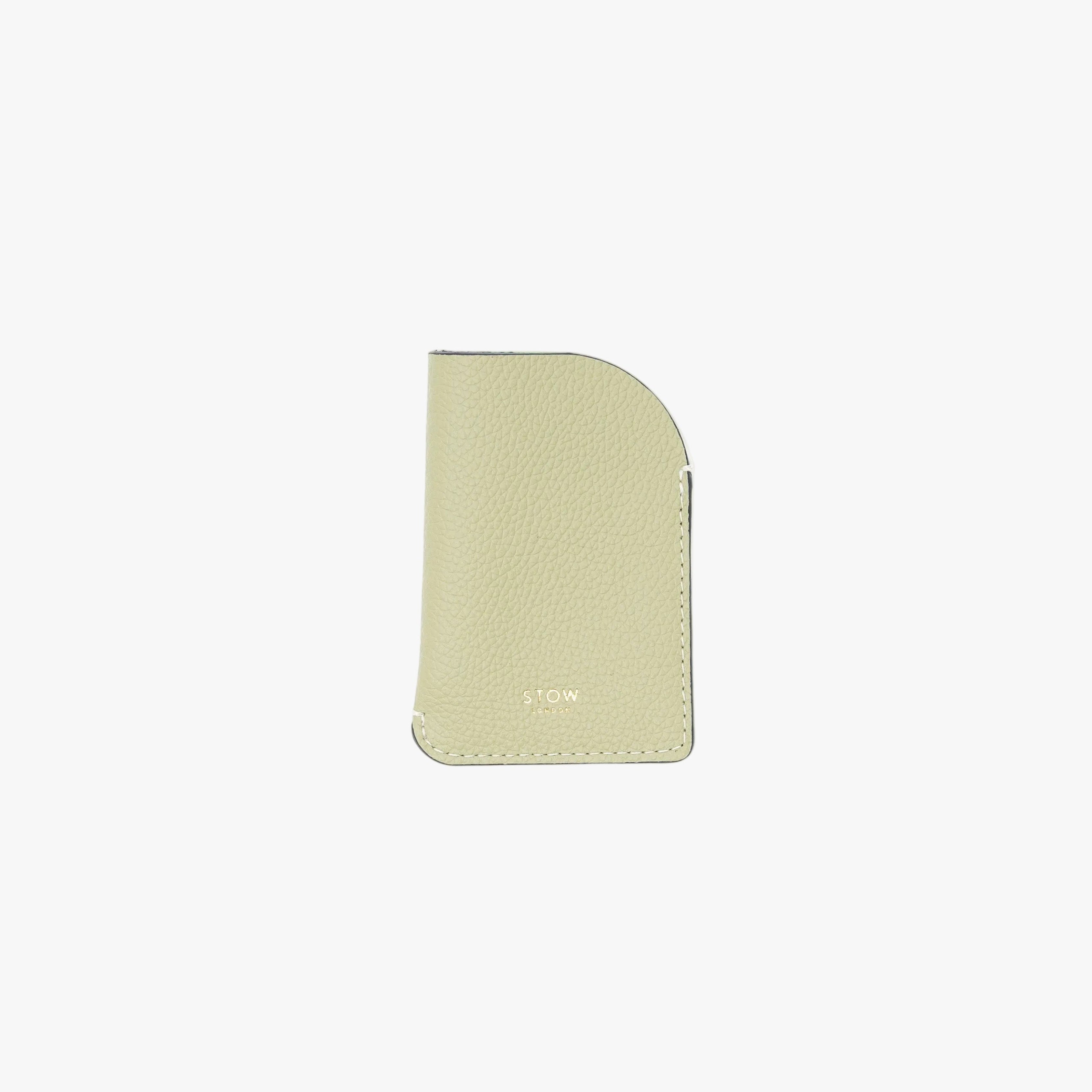 STOW London's Mini Cardholder in Pale Green pebbled leather on a light grey background featuring a small gold embossed logo on the front bottom