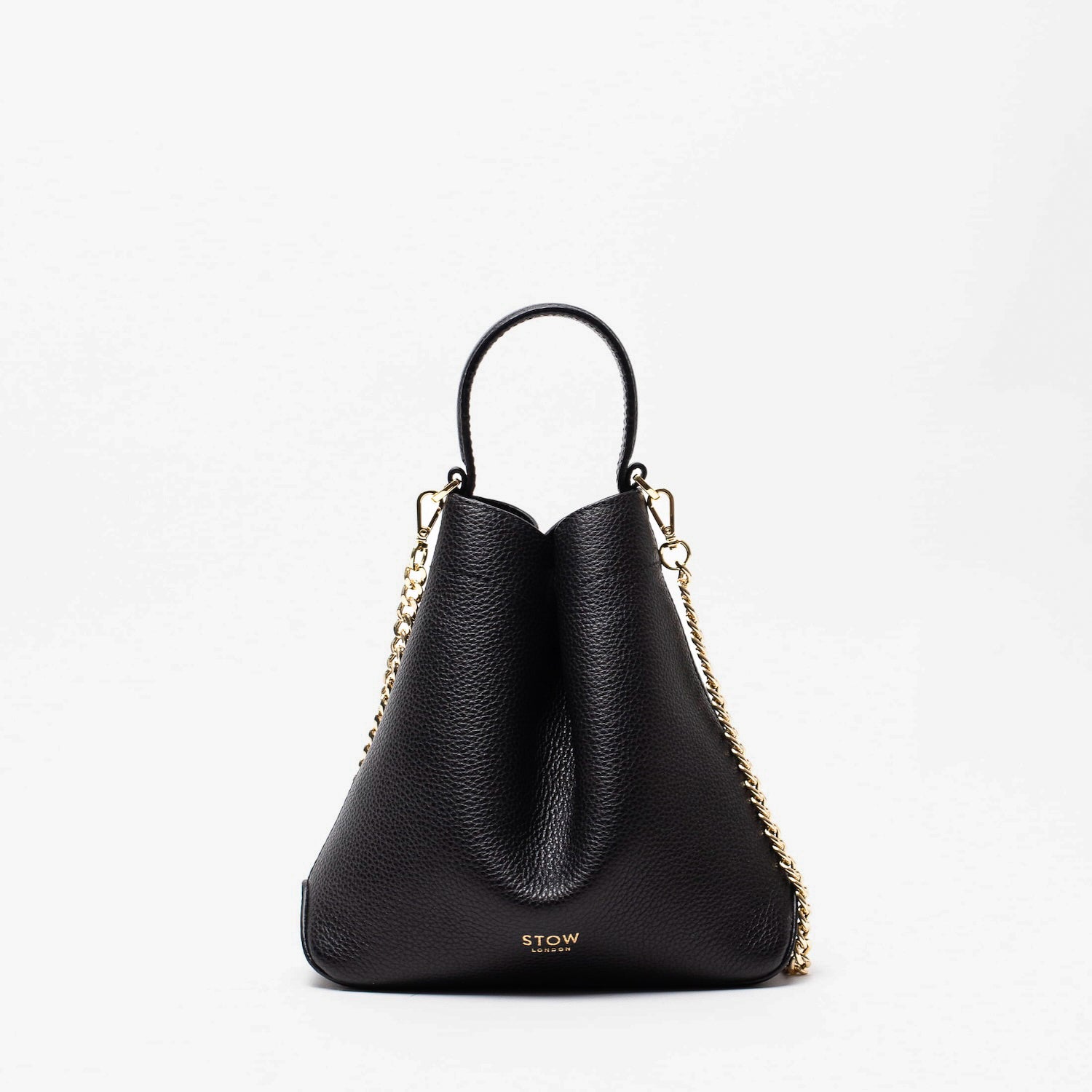 STOW London's Mini Curve in Black pebbled leather and detachable gold chain crossbody strap on a light grey background 