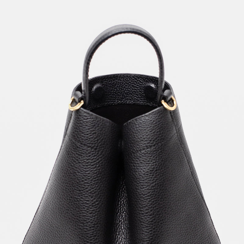 Close up of STOW London's Mini Curve in Black pebbled leather featuring hidden magnets, suede lining and gold hardware on a light grey background 