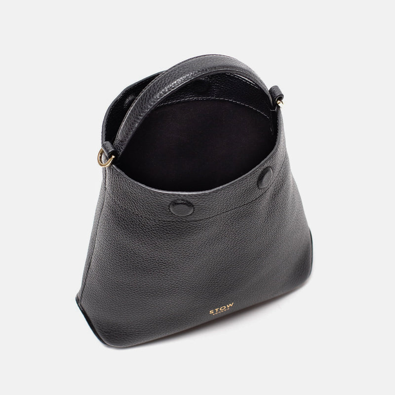 STOW London's Mini Curve in Black pebbled leather with magnets open showing black suede interior lining on a light grey background 