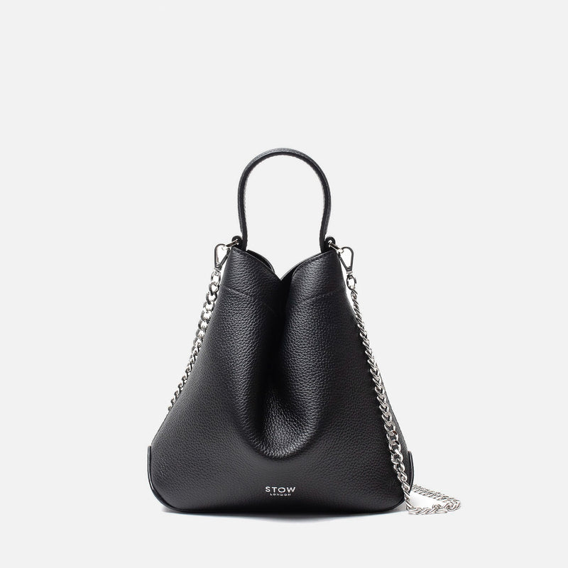 Stow London's Mini Curve in Black pebbled leather and detachable silver chain crossbody strap on a light grey background 