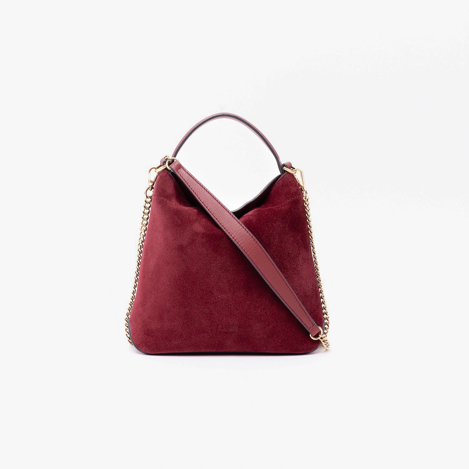 Stow London's Mini Curve in Burgundy suede leather and detachable gold chain crossbody strap styled as a flap bag on a light grey background 