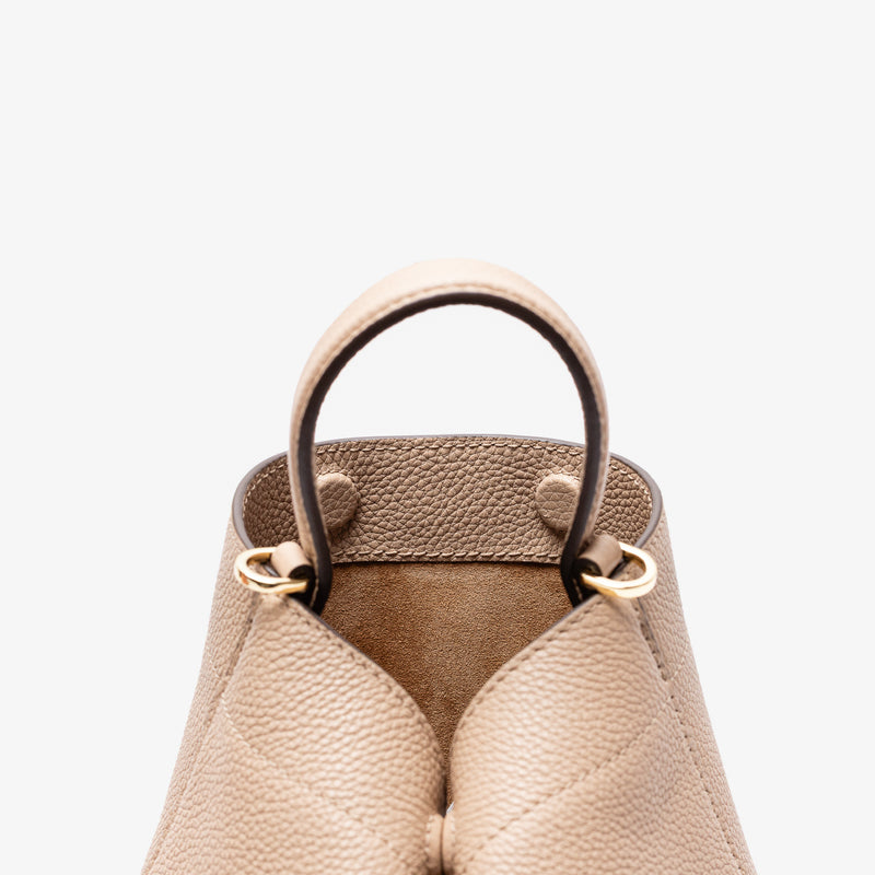 Close up of the top of Stow London's Mini Curve in Camel pebbled leather featuring the hidden magnets, suede interior lining and gold hardware on a light grey background 