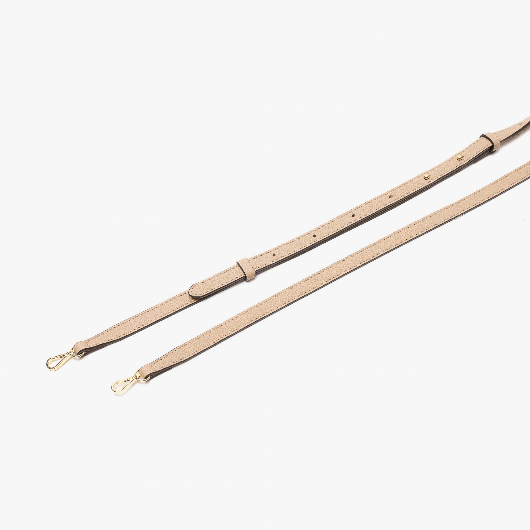 Close up of the detachable leather crossbody strap for STOW London's Mini Curve in Camel pebbled leather on a light grey background 