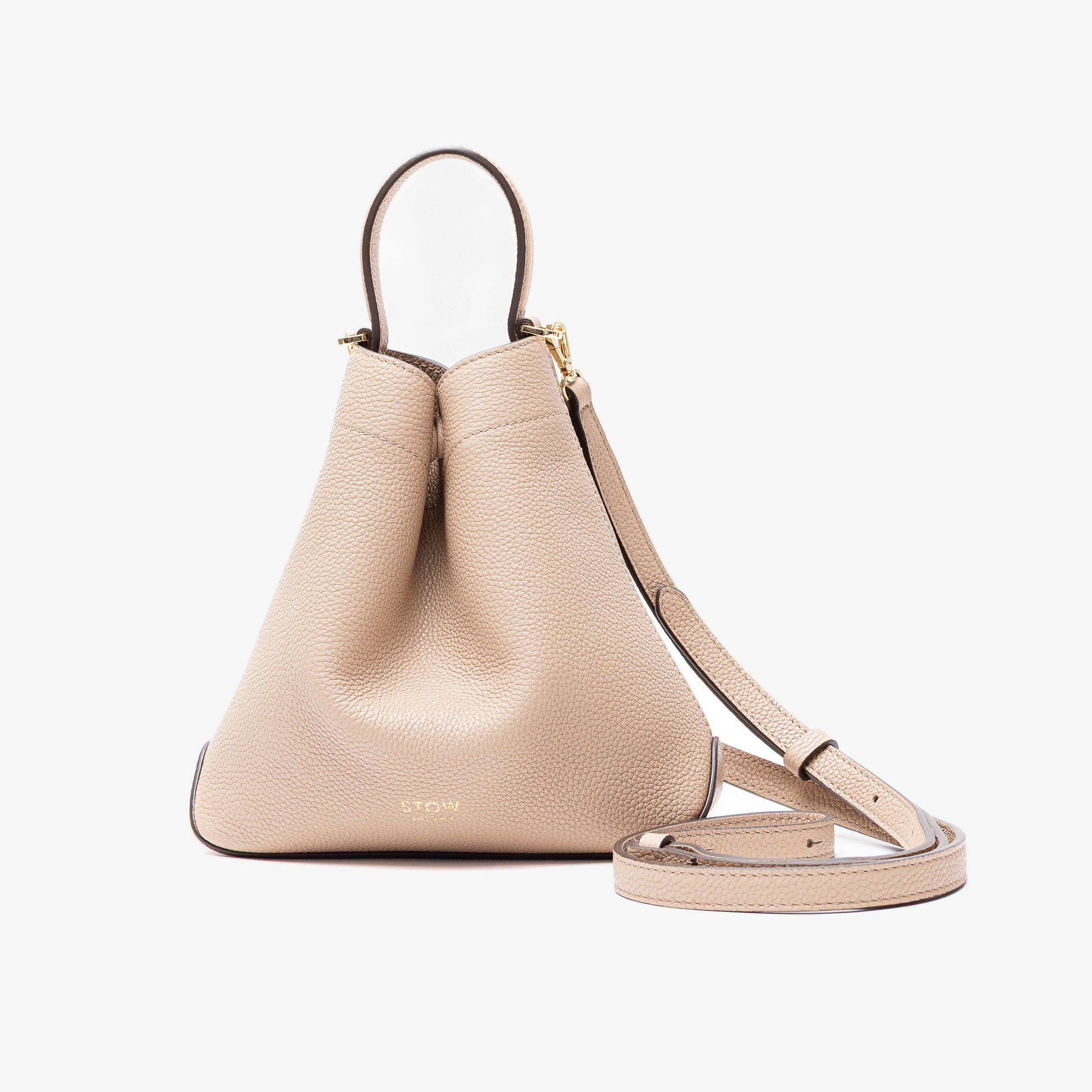 STOW London's Mini Curve in Camel pebbled leather and detachable leather crossbody strap on a light grey background 