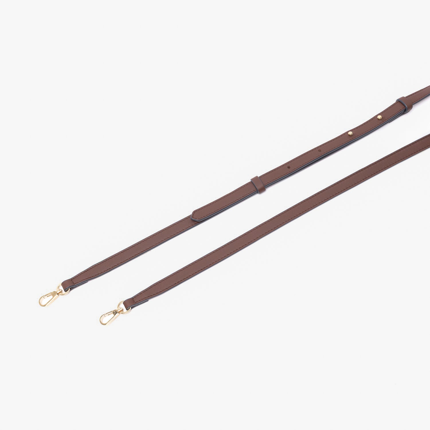 Close up of the detachable leather crossbody strap for STOW London's Mini Curve in Chocolate suede leather on a light grey background 