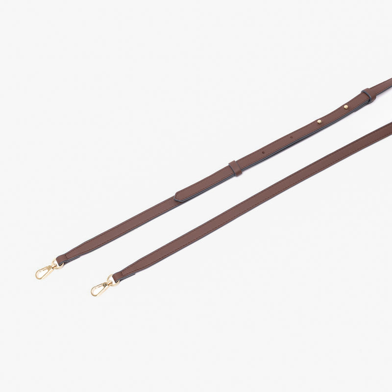 Close up of the detachable leather crossbody strap for STOW London's Mini Curve in Chocolate suede leather on a light grey background 