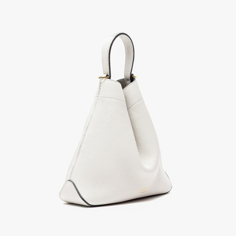 Off-axis view of Stow London's Mini Curve in Cloud Grey pebbled leather on a light grey background 