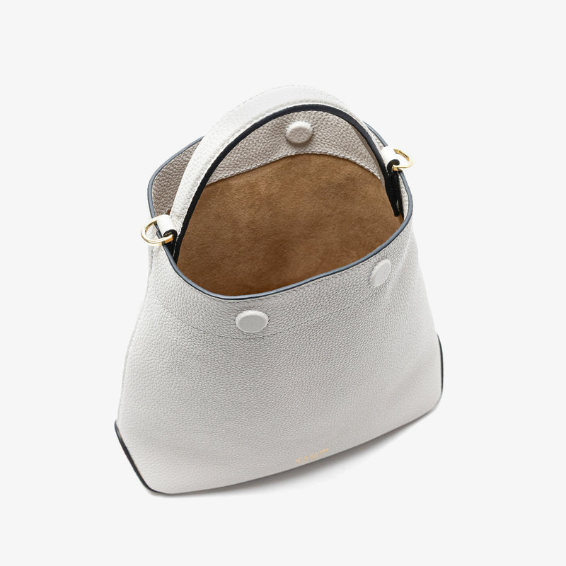 Stow London's Mini Curve in Cloud Grey pebbled leather with magnets open showing hidden magnet closures and cognac suede interior lining on a light grey background 