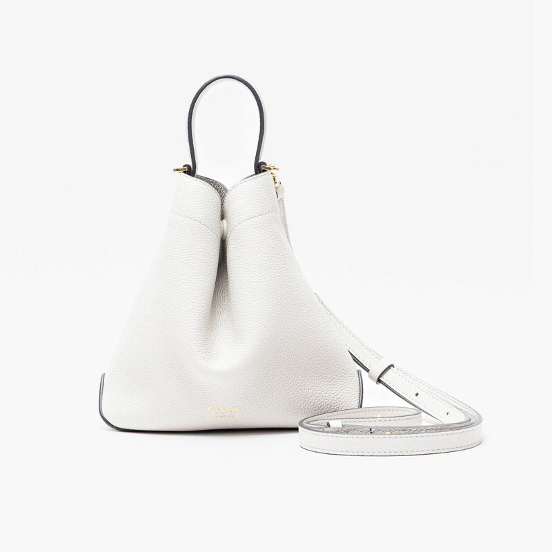 STOW London's Mini Curve in Cloud Grey pebbled leather and detachable leather crossbody strap on a light grey background 