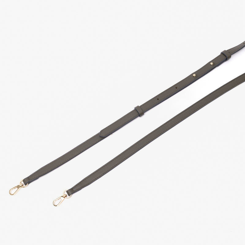 Close up of detachable leather crossbody strap from STOW London's Mini Curve in Dark Green suede leather on a light grey background 