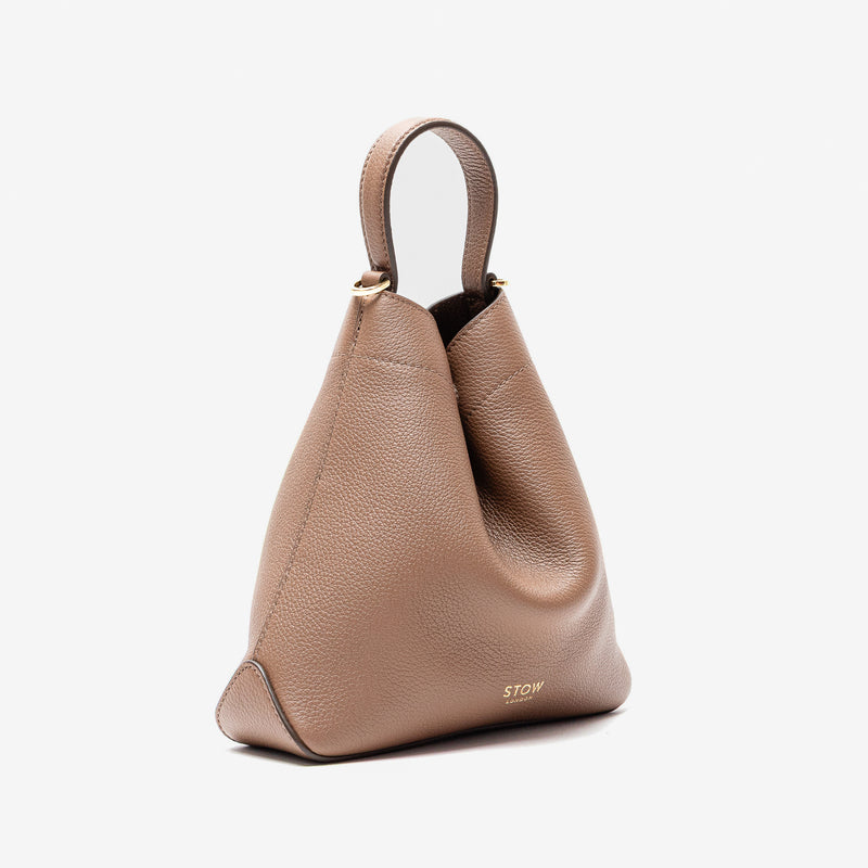 Off-axis view of Stow London's Mini Curve in Mocha pebbled leather on a light grey background 