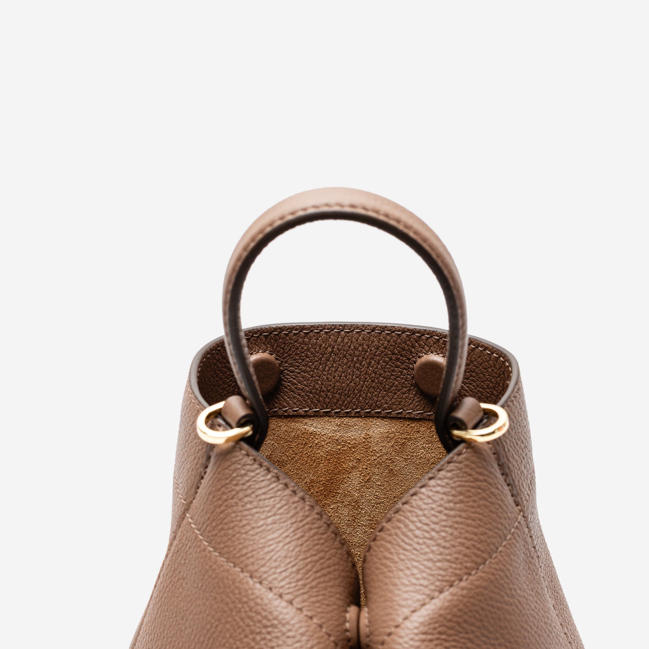 Close up of Stow London's Mini Curve in Mocha pebbled leather featuring the hidden magnets, suede interior lining and gold hardware on a light grey background 