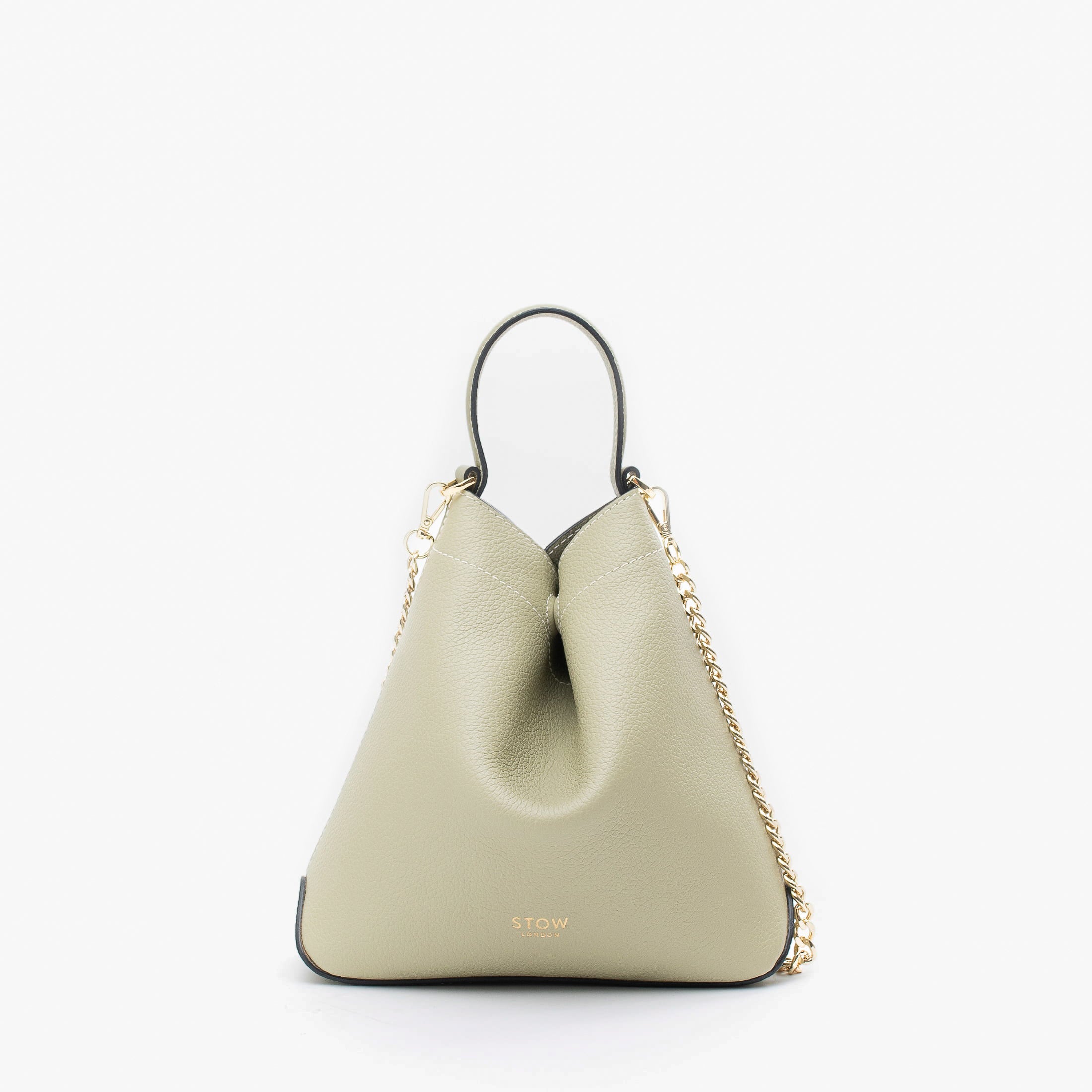 STOW London's Mini Curve in Pale Green pebbled leather and detachable gold chain crossbody strap on a light grey background 
