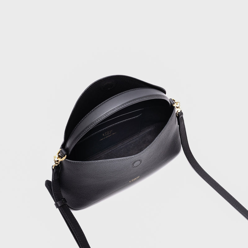 STOW London's Mini East West in Black pebbled leather with flap open showing suede interior and slip pocket featuring gold-coated stainless steel hardware on a light grey background