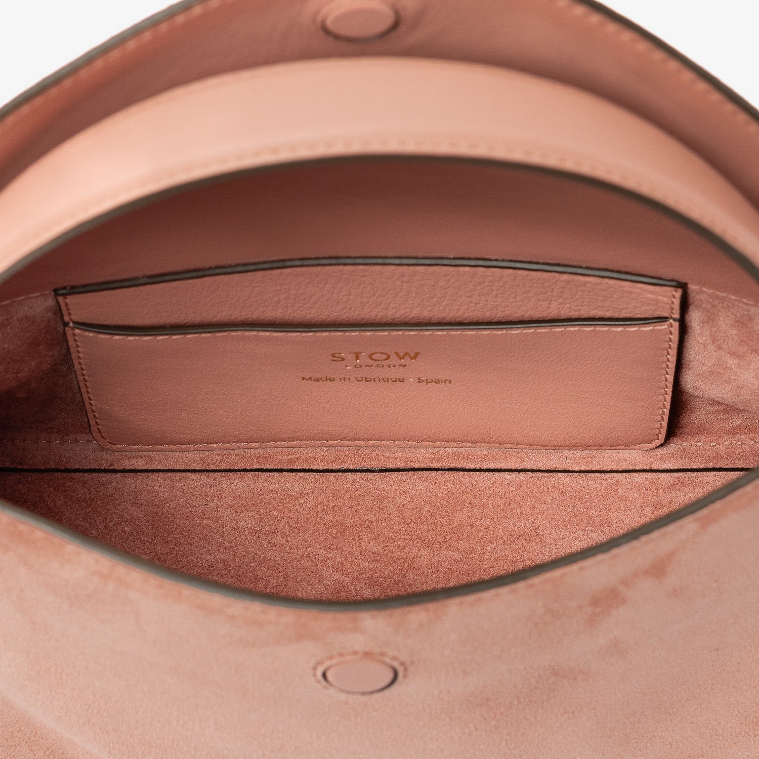 Close up of the interior of STOW London's Mini East West in Hazy Blush suede leather featuring internal slip pocket on a light grey background
