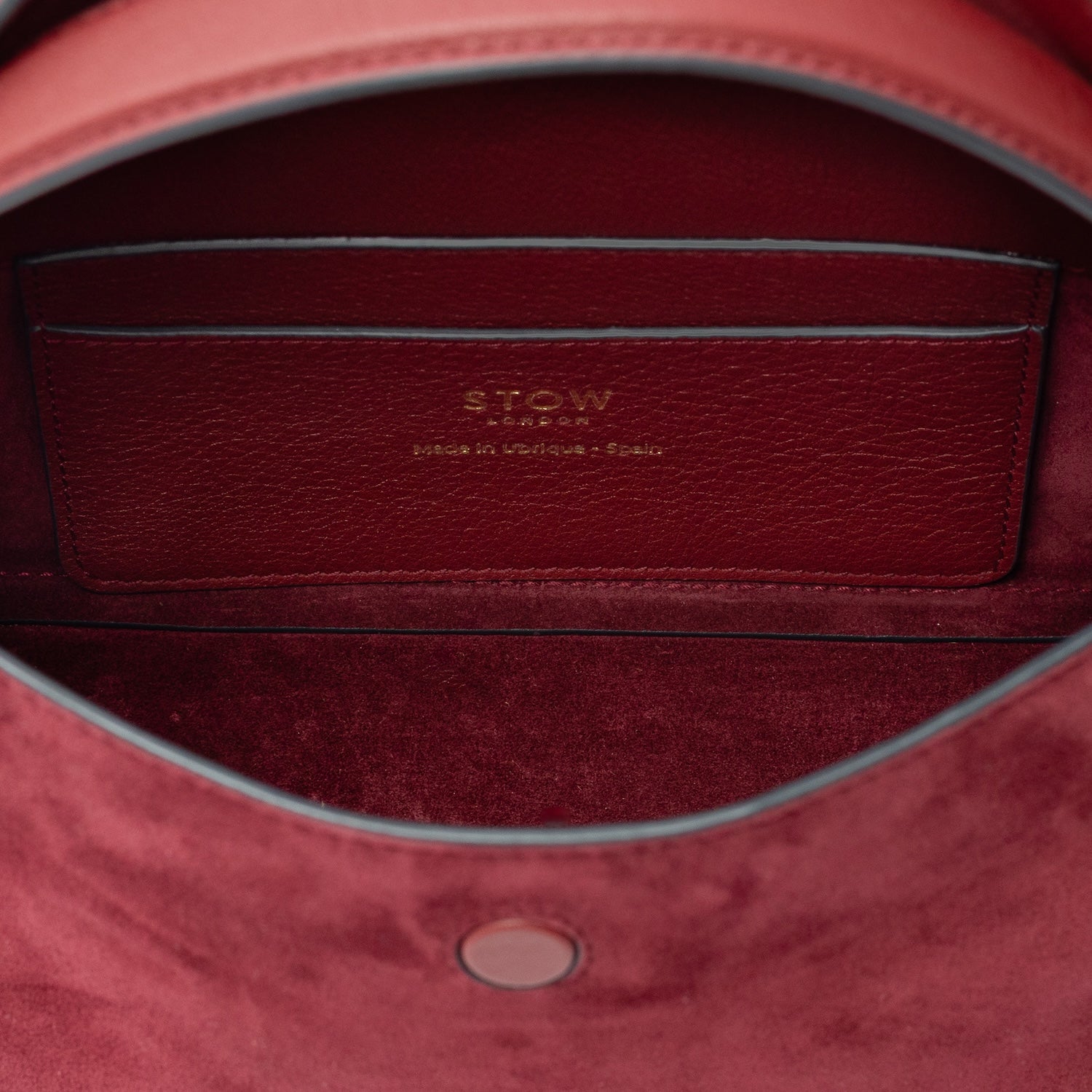 Interior view of STOW London's Mini East West bag in Burgundy Suede leather showing the interior card holder pocket featuring gold details