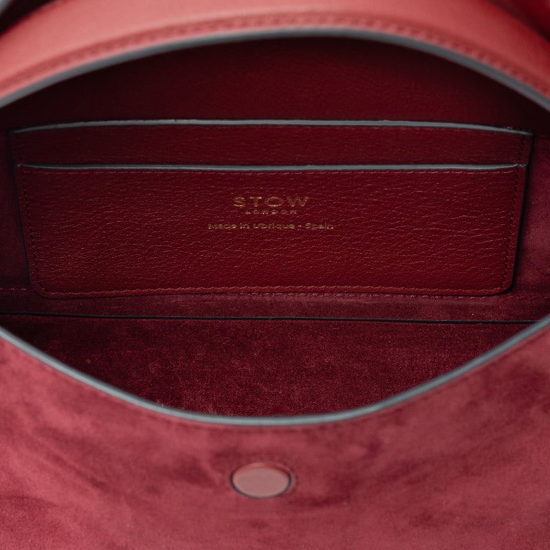 Interior view of STOW London's Mini East West bag in Burgundy Suede leather showing the interior card holder pocket featuring gold details