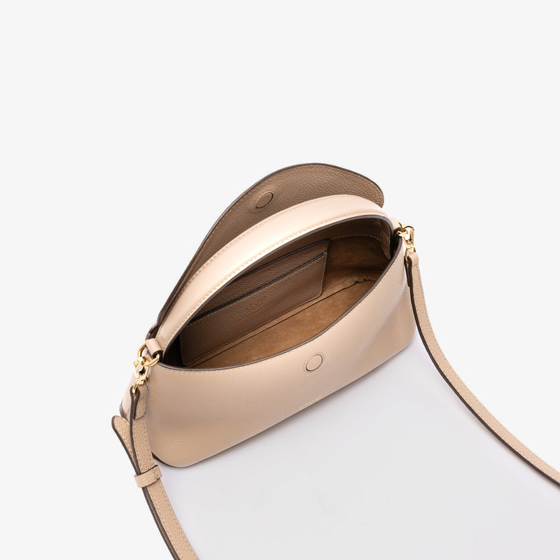 STOW London's Mini East West in Camel pebbled leather with flap open showing suede interior and slip pocket featuring gold-coated stainless steel hardware on a light grey background