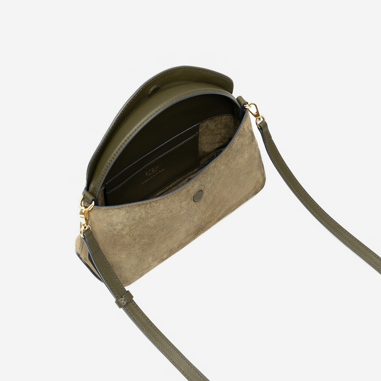 STOW London's Mini East West in Dark Green suede leather with flap open showing suede interior and slip pocket featuring gold-coated stainless steel hardware on a light grey background