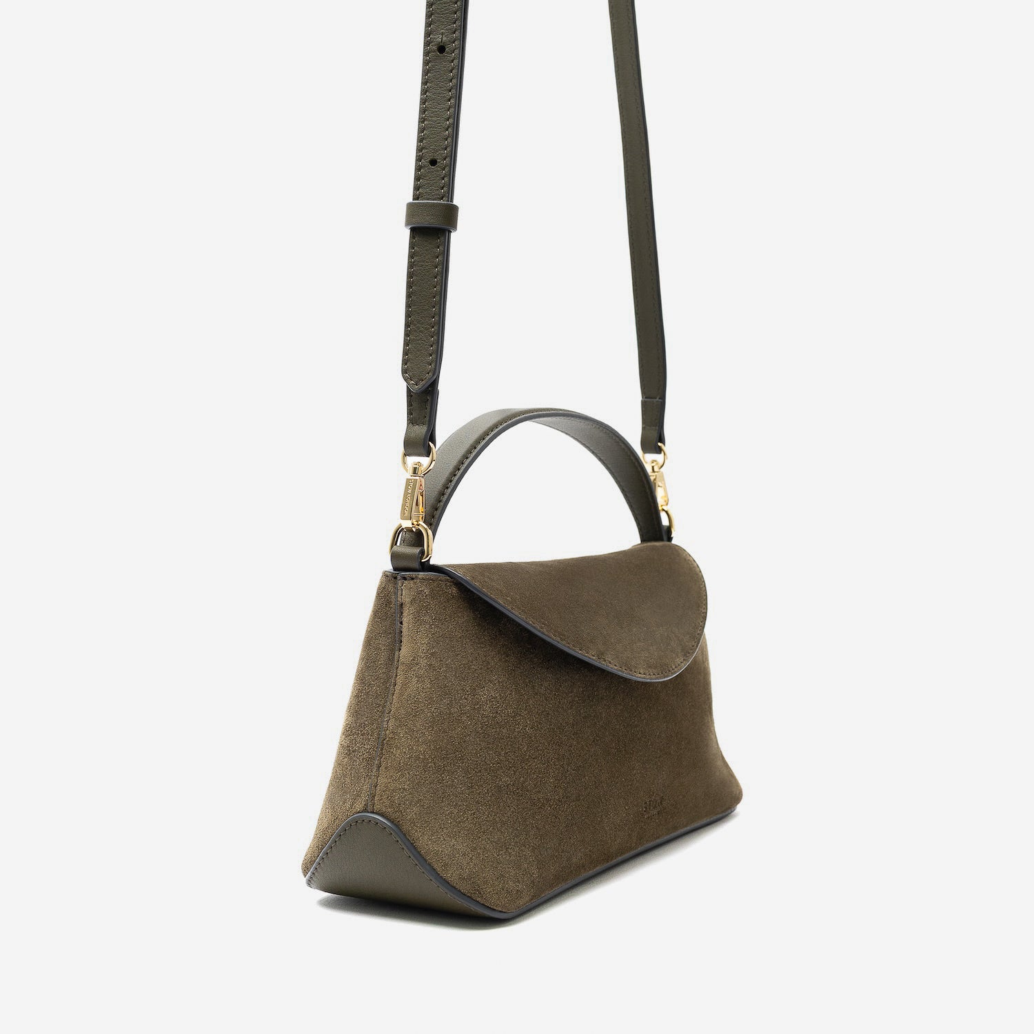 Off-axis view of STOW London's Mini East West in Dark Green suede leather and detachable crossbody strap featuring gold-coated stainless steel hardware on a light grey background