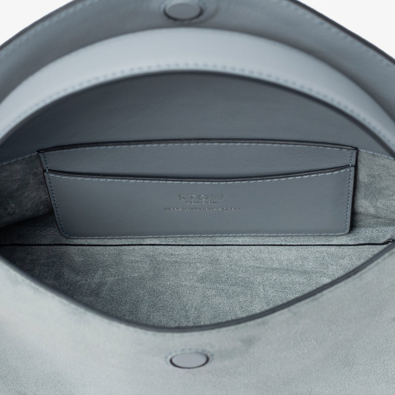 Close up of the interior of STOW London's Mini East West in Misty Blue suede leather featuring internal slip pocket on a light grey background
