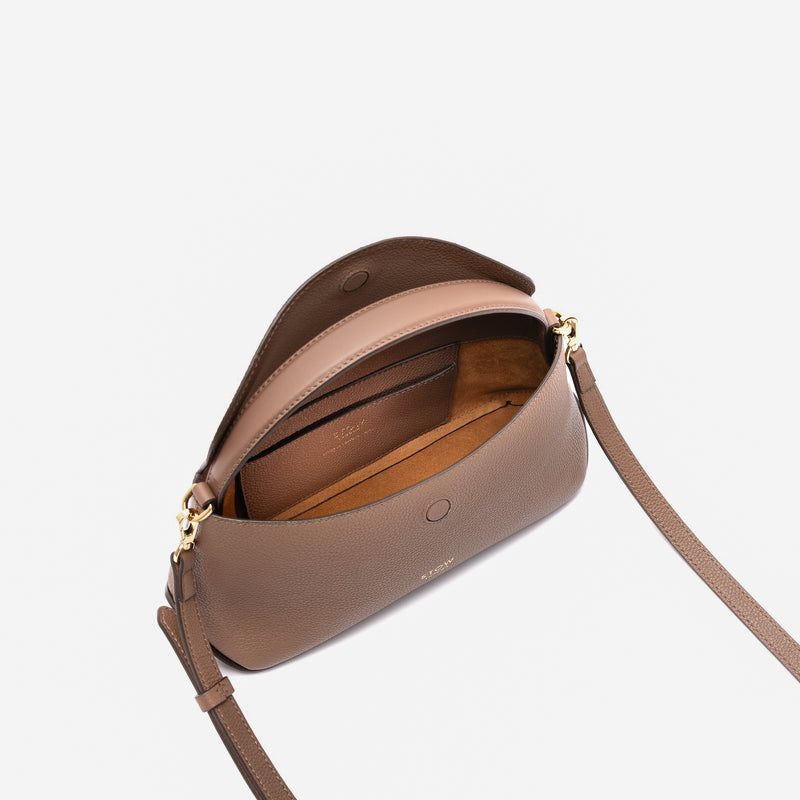 STOW London's Mini East West in Mocha pebbled leather with flap open showing suede interior and slip pocket featuring gold-coated stainless steel hardware on a light grey background