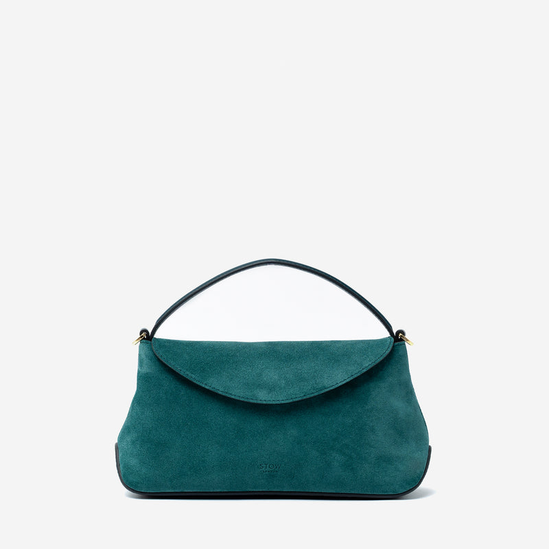STOW London's Mini East West in Ocean Teal suede leather featuring gold-coated stainless steel hardware on a light grey background