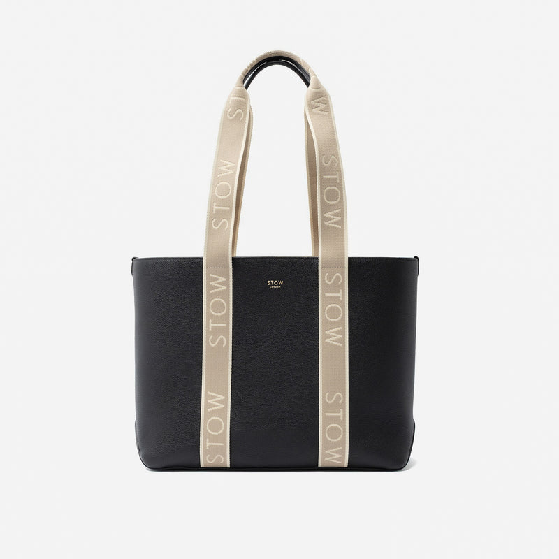 STOW London's Nastro Tote bag in Black pebbled leather with beige nastro handles featuring 'STOW' branding on a light grey background