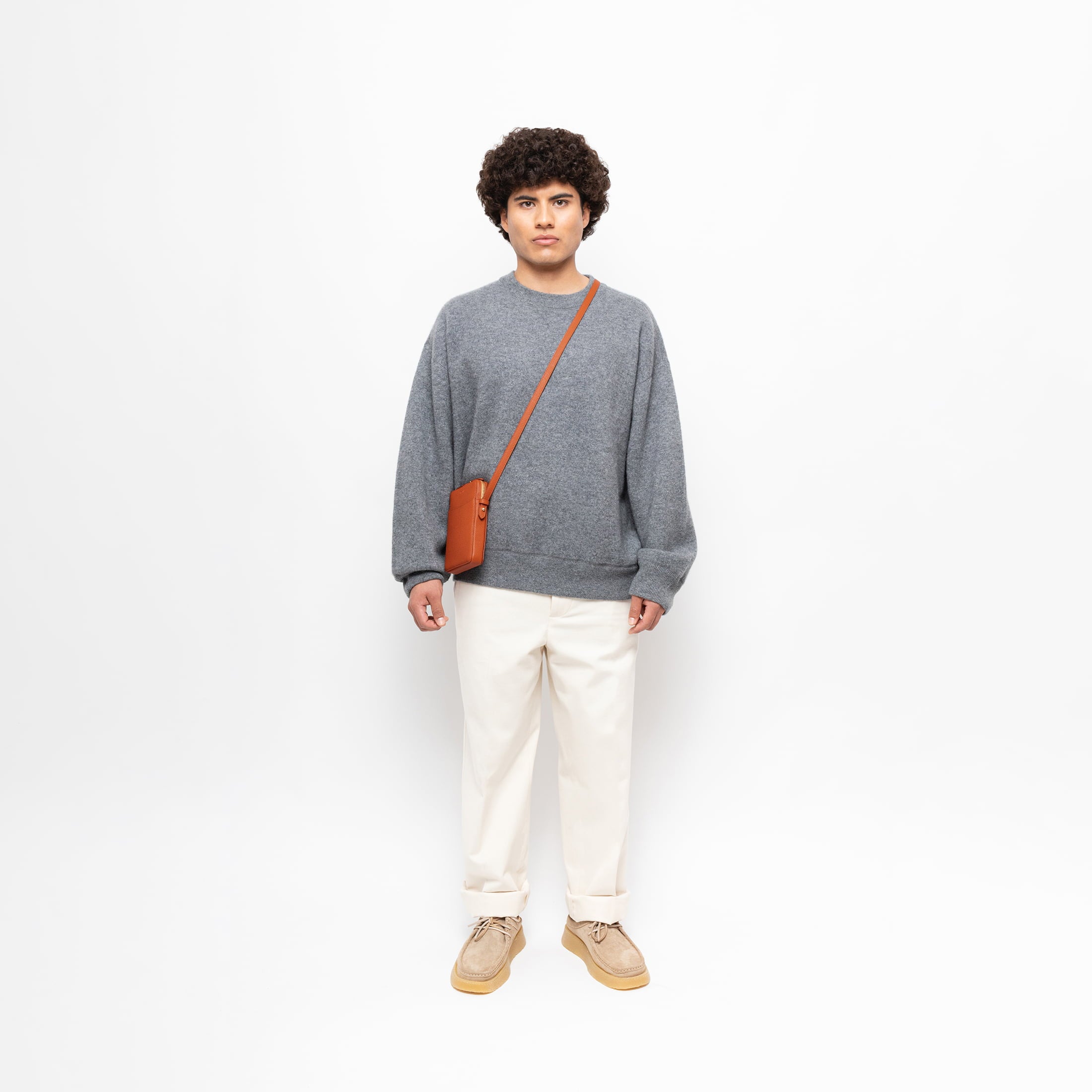 STOW London Clay Orange Phone Crossbody carried by male model