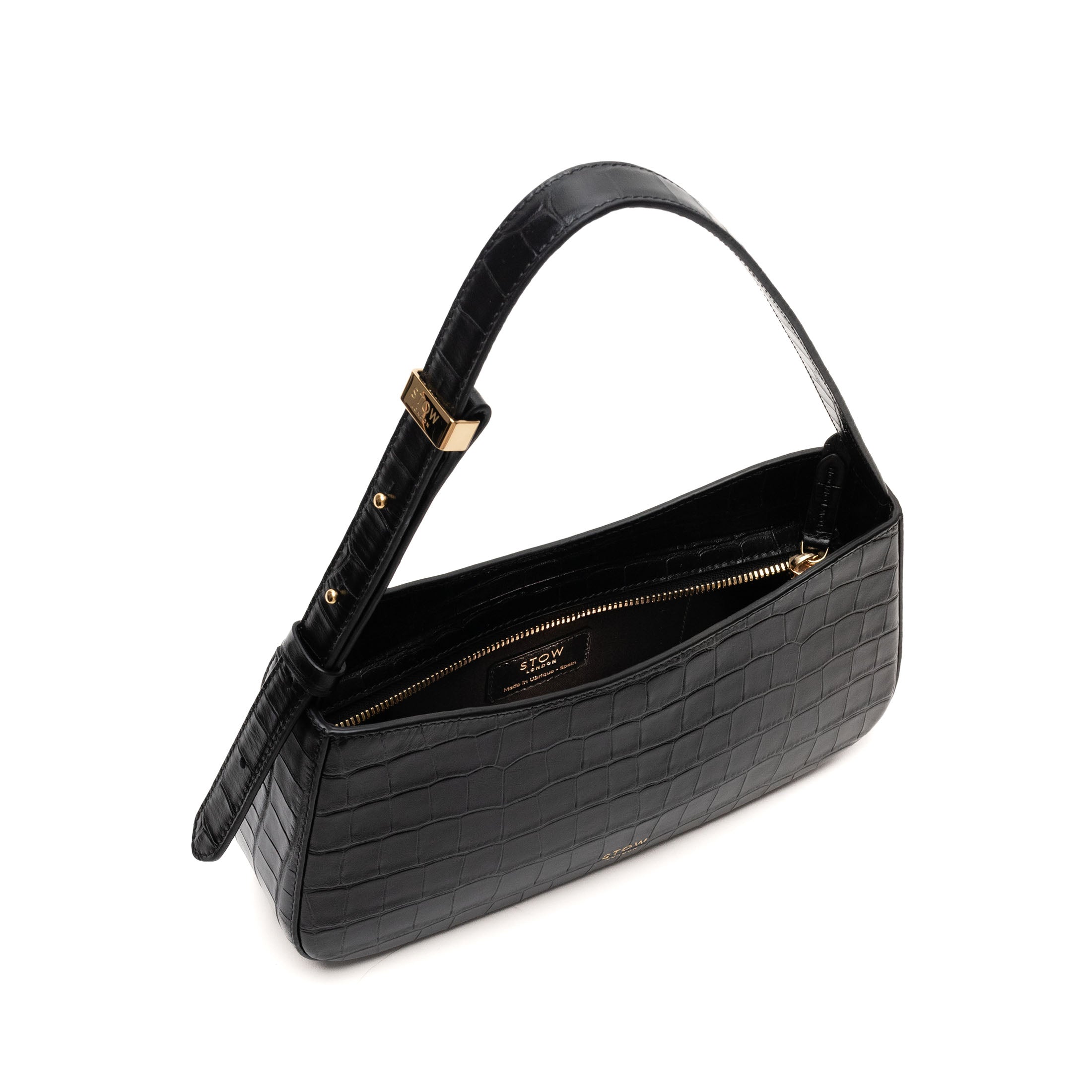 Top angled view of STOW London's Post Shoulder bag in Black Embossed Croc leather with zipper open showing the bag's interior featuring gold-coated stainless steel hardware and brand engravings on a white background