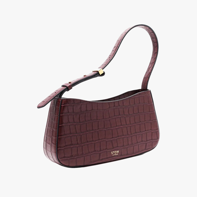STOW London's Post Shoulder in Burgundy Embossed Croc leather on a light grey background featuring gold-coated stainless steel hardware