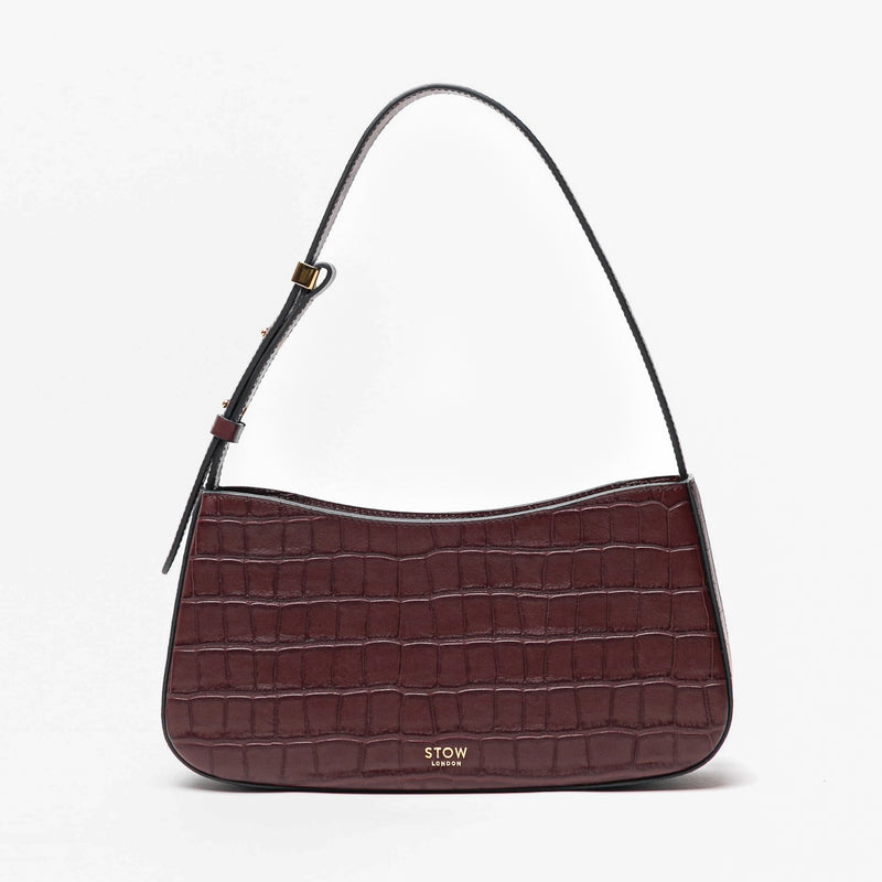 Stow London's Post Shoulder in Burgundy Embossed Croc leather on a light grey background featuring gold-coated stainless steel hardware