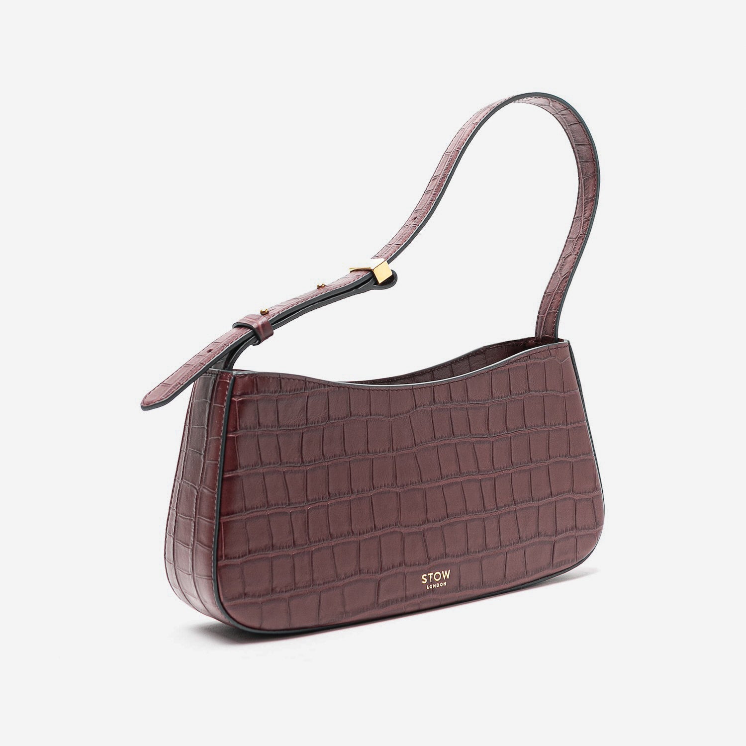Off-axis view of Stow London's Post Shoulder in Burgundy Embossed Croc leather on a light grey background featuring gold-coated stainless steel hardware