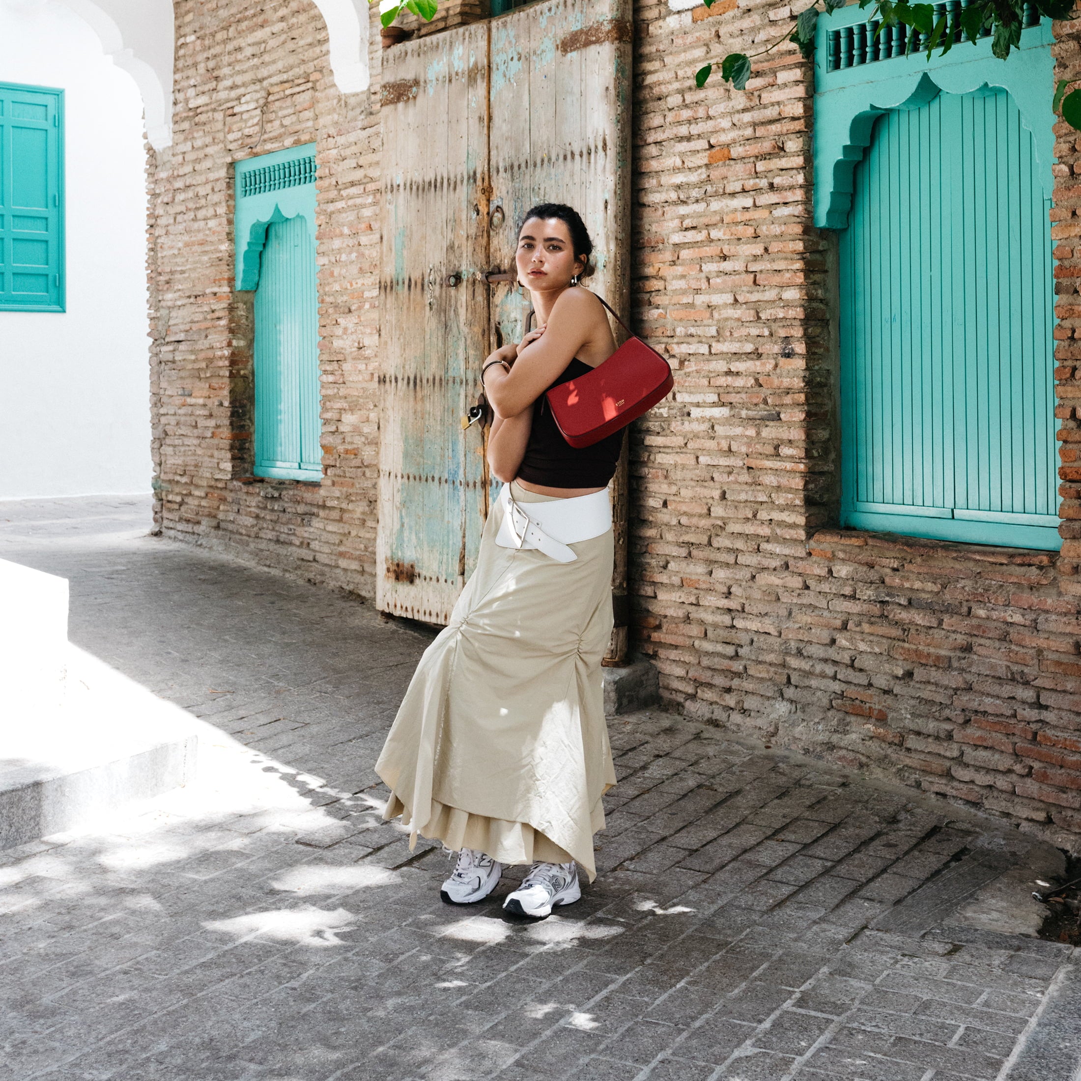 STOW London Post Shoulder Bag in Red leather being worn by model in Tangiers