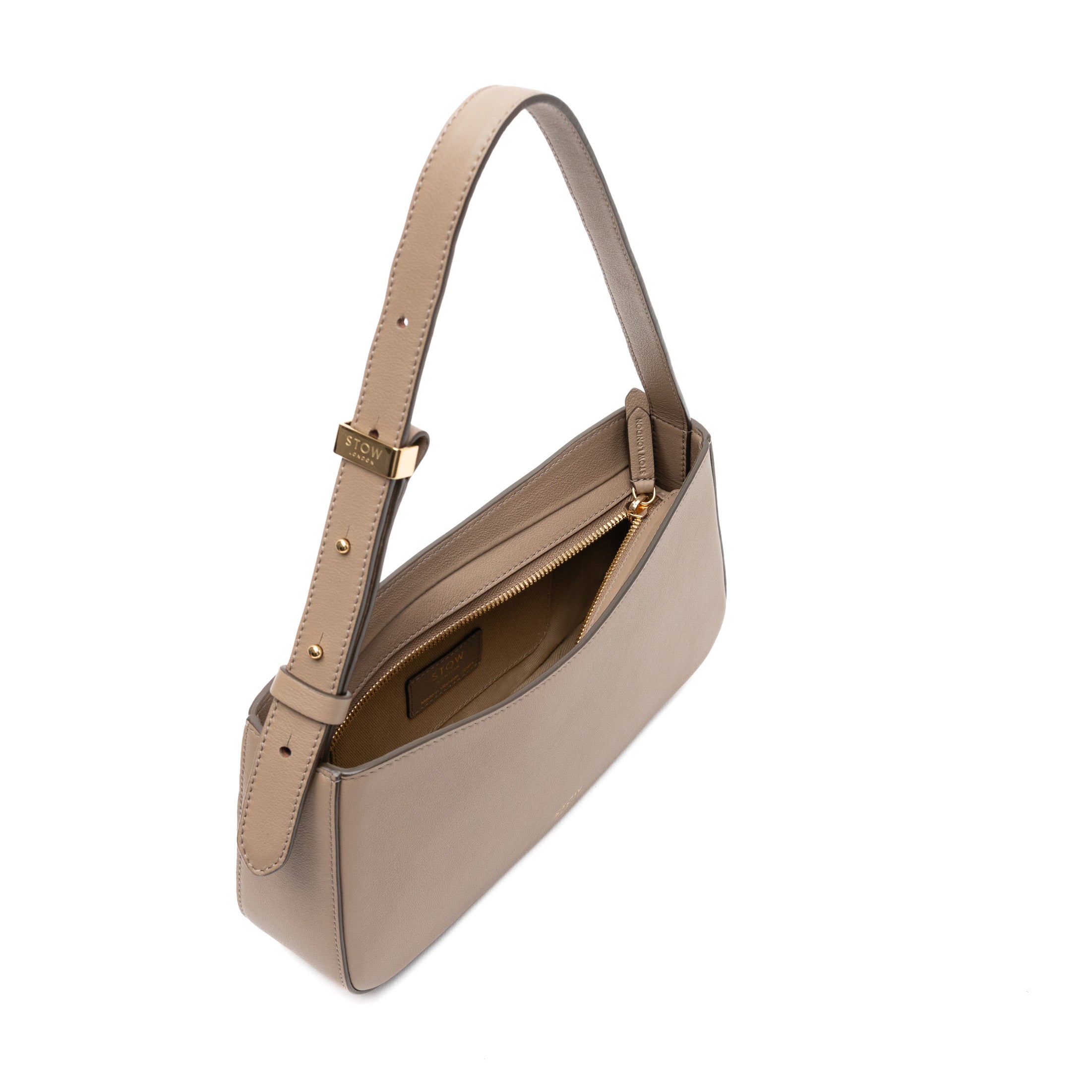 Top view of STOW London's Post Shoulder bag in Warm Taupe smooth leather with zipper open showing the bag's interior featuring gold-coated stainless steel hardware on a white background